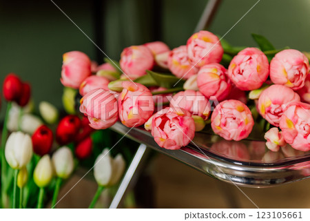 tulips bouquet on metal chair against green walls. flowers for women's day. pink flower buds march 8 tulips bouquet on metal chair against green walls. flowers for women's day. pink flower buds march 8 123105661