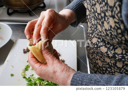 Senior woman stuffing ingredients into fried tofu 123105879