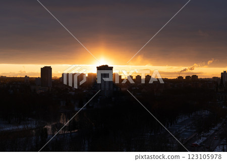 The rising sun is blocking a tall, residential building. Dawn in the city 123105978