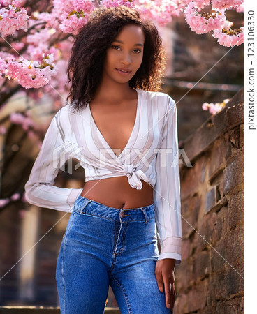Young woman standing in front of cherry blossoms 123106330