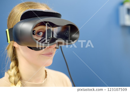 Neurologist performing positional testing of patient using videonystagmography . VNG testing uses goggles with infrared cameras to track eye movements, and can help to determine if the patient is Neurologist performing positional testing of patient using videonystagmography . VNG testing uses goggles with infrared cameras to track eye movements, and can help to determine if the patient is 123107509