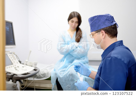 Mammalogist doctor is preparing to examine woman breasts and lymph nodes using ultrasound for diagnosis of breast cancer during appointment 123107522