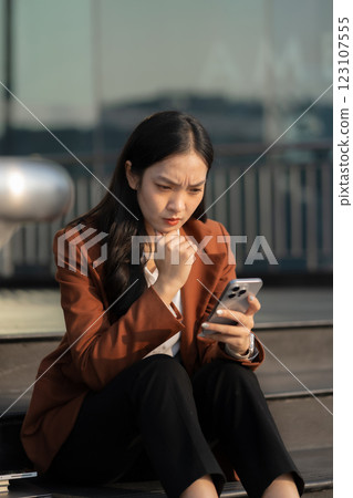 Depressed businesswoman sits on stairs outside office, overwhelmed by financial crisis, job loss, and stress. failure, burnout, and workplace pressure. 123107555
