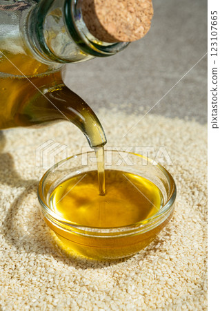 Unrefined cold-pressed sesame oil poured into a glass bowl Unrefined cold-pressed sesame oil poured into a glass bowl 123107665