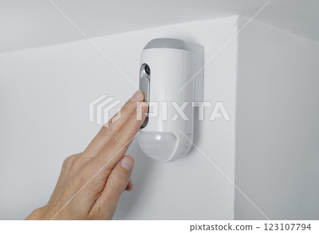 man connecting the camera of a burglar alarm 123107794