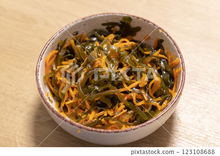 Close up shot of the salad made of carrots and seaweed in the clay bawl. Food 123108688