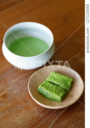 Cup of fresh matcha tea and Warabi mochi, traditional Japanese sweet from bracken starch on wooden table. Cup of fresh matcha tea and Warabi mochi, traditional Japanese sweet from bracken starch on wooden table. 123110088