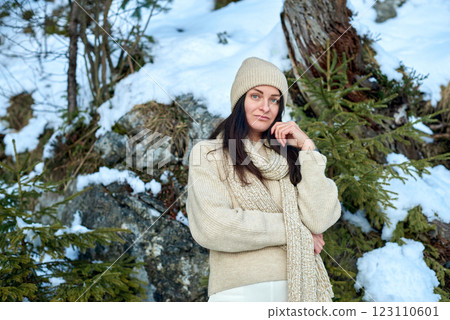 Serene Winter Portrait: Young Woman in Cream Sweater Contemplating Snowy Mountain Landscape with Evergreen Forest 123110601