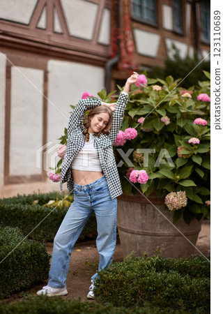 Autumn Fashion Portrait: Stylish Woman Amidst Blooming Hydrangeas at Traditional German Half Timbered House. Cozy Fall Outdoor Scene Showcasing Casual Outfit and Warm Colors in Picturesque Rural Autumn Fashion Portrait: Stylish Woman Amidst Blooming Hydrangeas at Traditional German Half Timbered House. Cozy Fall Outdoor Scene Showcasing Casual Outfit and Warm Colors in Picturesque Rural 123110689