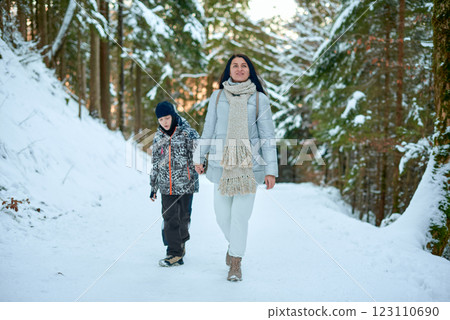 Woman and Boy Walking Hand in Hand in Snowy Forest, Serene Winter Scene with Snow-Covered Evergreen Trees, Soft Sunset Light, Peaceful and Reflective Mood, Perfect for Family and Nature Themes Woman and Boy Walking Hand in Hand in Snowy Forest, Serene Winter Scene with Snow-Covered Evergreen Trees, Soft Sunset Light, Peaceful and Reflective Mood, Perfect for Family and Nature Themes 123110690