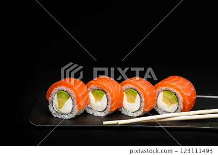 Delicious Fresh Salmon Sushi Rolls Presenting Exquisitely on a Black Background Delicious Fresh Salmon Sushi Rolls Presenting Exquisitely on a Black Background 123111493
