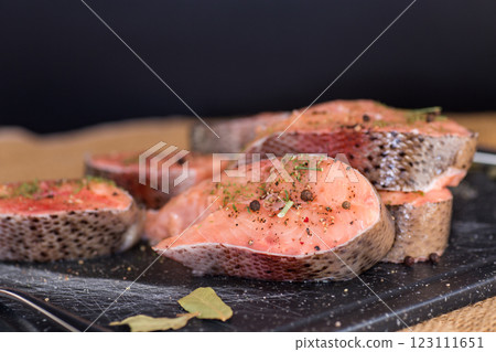 Natural piece of salmon with spices and herbs on a black background 123111651