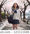 微笑的女學生沿著一排櫻花樹走到學校 123111686