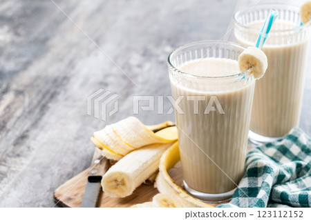 Fresh banana smoothie on white wooden table. 123112152