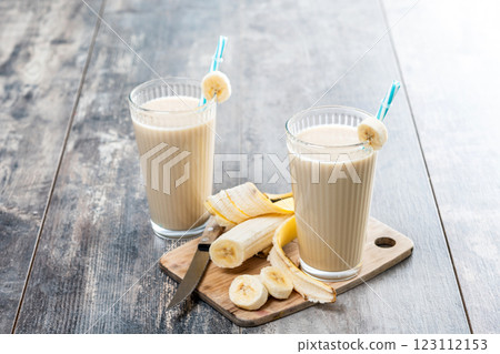 Fresh banana smoothie on white wooden table. 123112153