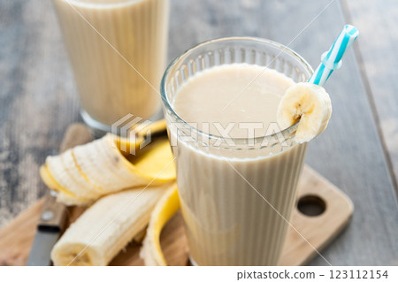 Fresh banana smoothie on white wooden table. 123112154