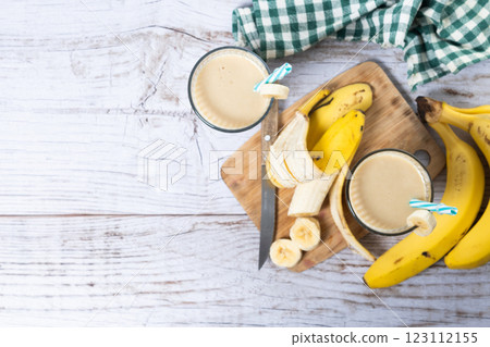 Fresh banana smoothie on white wooden table. 123112155