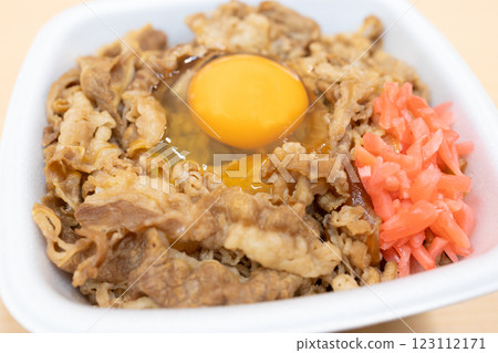 美味的牛肉便當，上面放著生雞蛋，並點綴著醃薑 123112171