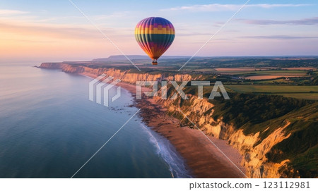 A vibrant hot air balloon soars over a stunning coastal vista. The cliffs and sea create a breathtaking landscape. Experience the beauty from above. Generative AI 123112981