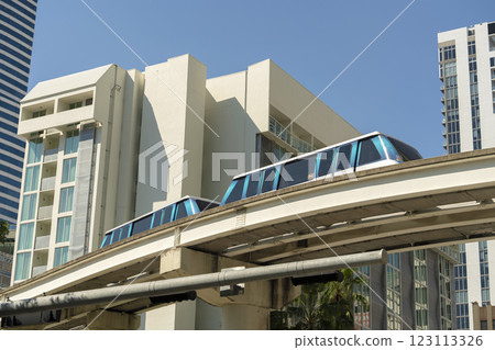 Public transportation in downtown Miami in Florida USA. Metrorail city train car on high railroad over street traffic between skyscraper buildings in modern American megapolis Public transportation in downtown Miami in Florida USA. Metrorail city train car on high railroad over street traffic between skyscraper buildings in modern American megapolis 123113326