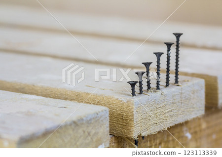 Positive graph made of screws as bar charts on board background Positive graph made of screws as bar charts on board background 123113339