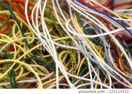 Multi-colored tangled colorful needlecraft silk thread rope. Macro shot. Abstract colors background Multi-colored tangled colorful needlecraft silk thread rope. Macro shot. Abstract colors background 123113472