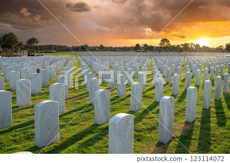 Memorial Day concept. Sarasota National Cemetery with rows of white tomb stones on green grass at sunset 123114072