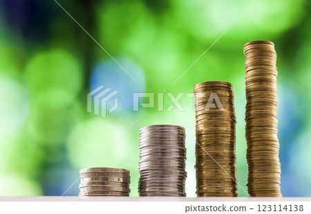 Growing coins stacks with green and blue sparkling bokeh background. Financial growth, saving money, business finance wealth and success concept. Growing coins stacks with green and blue sparkling bokeh background. Financial growth, saving money, business finance wealth and success concept. 123114138