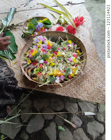 Traditional balinese offerings to gods in Bali with flowers and aromatic sticks Traditional balinese offerings to gods in Bali with flowers and aromatic sticks 123114421
