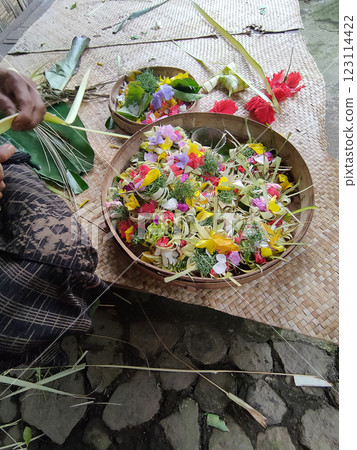 Traditional balinese offerings to gods in Bali with flowers and aromatic sticks 123114422