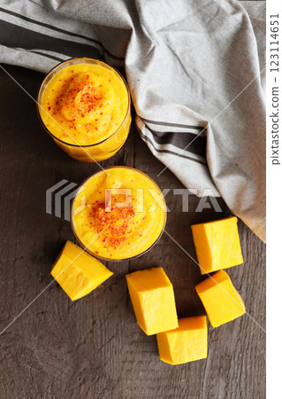 Raw vegan pumpkin butternut squash smoothie with spices in glass . Ingredients on dark stone background. Healthy drink. 123114651