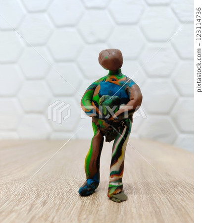 A Colorful and Artistic Clay Figurine Displayed in a Unique and Creative Pose for All to Enjoy 123114736