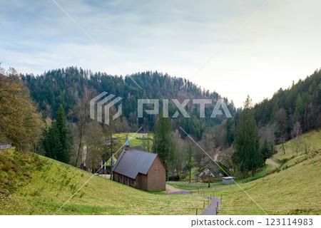 Idyllic German Countryside: Charming Brick Chapel Nestled in Lush Black Forest Valley. Picturesque Rural Landscape with Traditional Houses and Verdant Hills in Scenic Southern Germany Idyllic German Countryside: Charming Brick Chapel Nestled in Lush Black Forest Valley. Picturesque Rural Landscape with Traditional Houses and Verdant Hills in Scenic Southern Germany 123114983