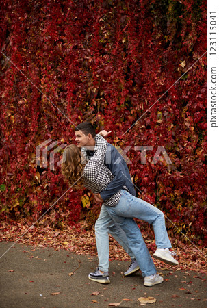 Young Cute Female Hugs Boyfriend. In Autumn Outdoor. Lovers Walking in Park. Attractive Funny Couple. Lovestory in Forest. Man and Woman. Cute Lovers in the Park. Family Concept. Happy Couple. 123115041