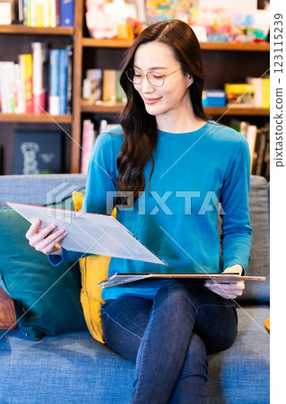 一位年輕女子邊喝咖啡邊拿著唱片 一位年輕女子邊喝咖啡邊拿著唱片 123115239