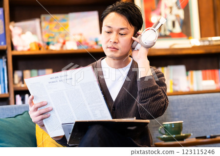 A middle-aged man listening to a record through headphones A middle-aged man listening to a record through headphones 123115246