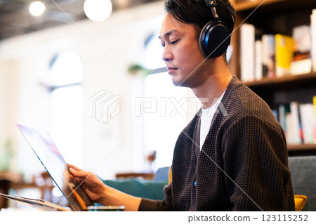 一名中年男子戴著耳機聽唱片 一名中年男子戴著耳機聽唱片 123115252