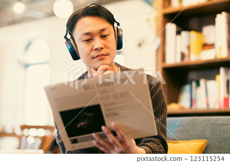 一名中年男子戴著耳機聽唱片 123115254