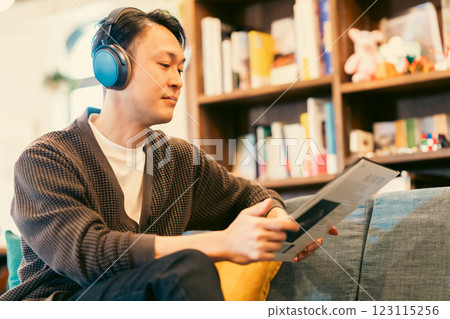 A middle-aged man listening to a record through headphones A middle-aged man listening to a record through headphones 123115256