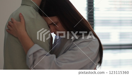 A married couple reconciles after a fight. They hug. The woman is crying. Relationship crisis. 123115360
