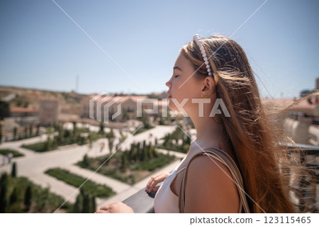 Woman, Landscape, View. Young woman gazes at the scenic cityscape from a balcony. 123115465