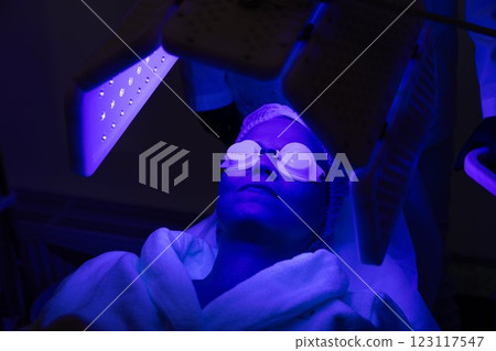 Relaxing facial treatment with blue light therapy in a spa setting 123117547