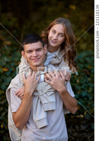 Embracing Teen Love in the Greenery of the Park. Whispers of Love: Teen Couple's Outdoor Embrace in the Park. 123118136