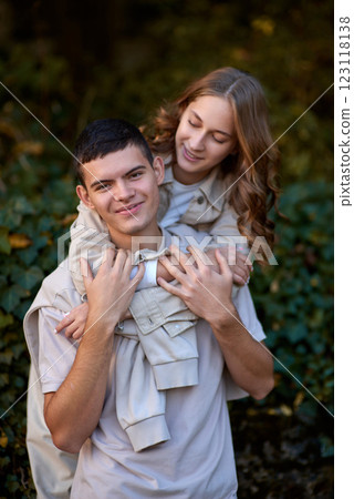 Teen couple in love in the park. Lovely young engaged couple embracing and smiling after kissing against sunset. Smooth Focus, Valentine couples walking. Lovers love concept. 123118138