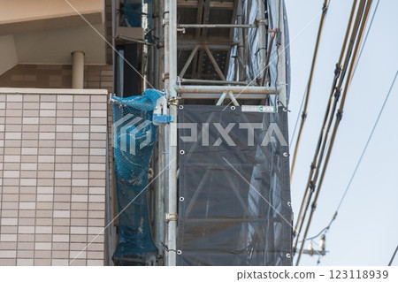 [Large-scale apartment building repair work: scaffolding and electric wires] 123118939