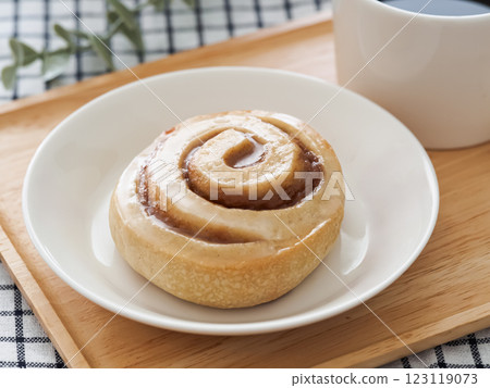 Cinnamon roll and hot coffee on a white plate 123119073