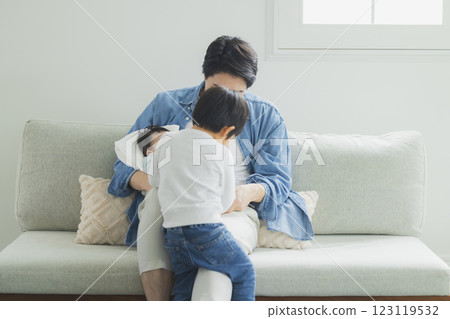 Father and child sitting on sofa 123119532