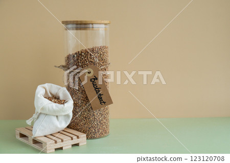 Raw buckwheat porridge in sustainable natural packaging. Refillable systems. Gluten free cereals. Health gut benefits. Concept of alternative whole spelt grain ingredient. Vegetarian diet recipes 123120708
