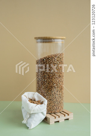 Raw buckwheat porridge in sustainable natural packaging. Refillable systems. Gluten free cereals. Health gut benefits. Concept of alternative whole spelt grain ingredient. Vegetarian diet recipes Raw buckwheat porridge in sustainable natural packaging. Refillable systems. Gluten free cereals. Health gut benefits. Concept of alternative whole spelt grain ingredient. Vegetarian diet recipes 123120726