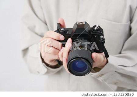 Man holding a film camera, white background, no face 123120880